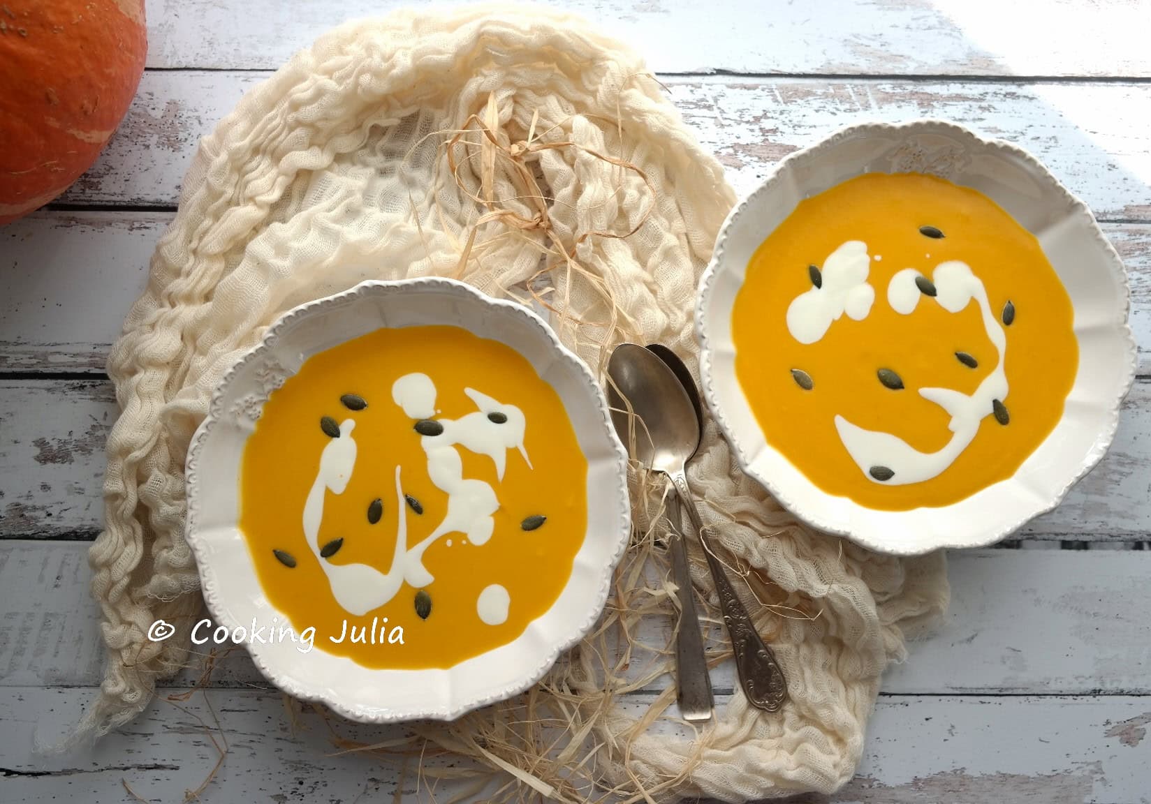 Deux assiettes de velouté de potimarron avec mise en scène rustique et potimarron frais